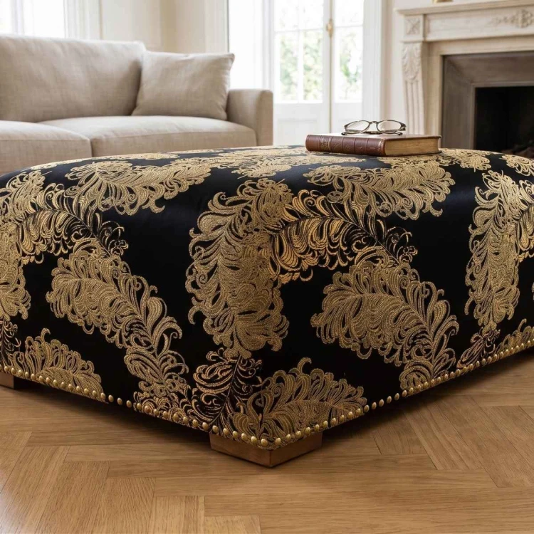 Złoto-czarna tkanina tapicerska żakardowa Diva ze świetlistym, barokowym wzorem – oferta Polskie Tkaniny aranżacja pufa